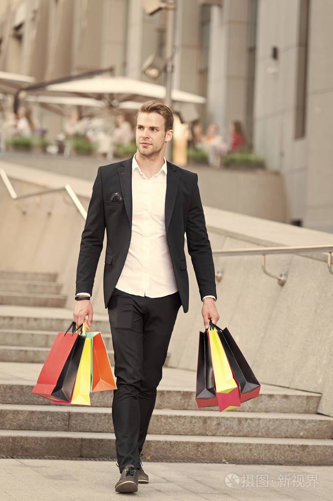 那个家伙提着一堆购物袋在黑色星期五购物的有利可图的交易男子在商场