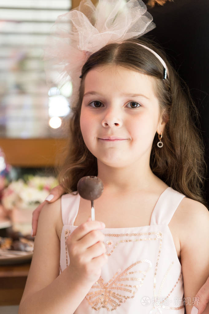 健康的营养和骗人的饭菜节日款待爱吃甜食小女孩吃圆糖果快乐的小孩