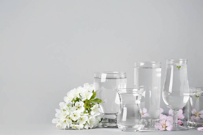 桌上有水和鲜花的玻璃杯