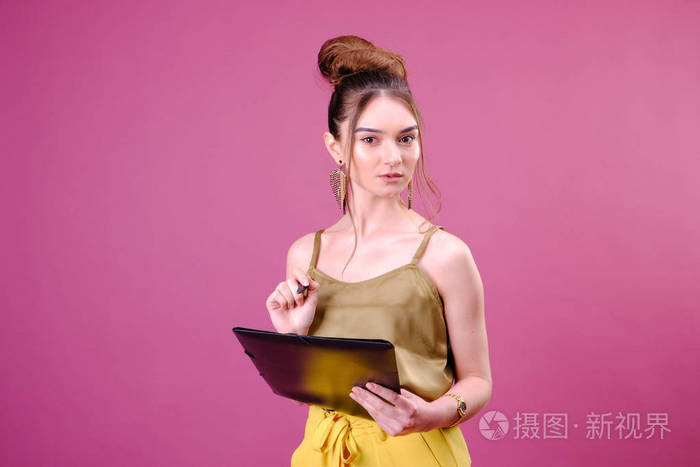 年轻漂亮的美女站着写字做笔记手里拿着课本笔记本和笔