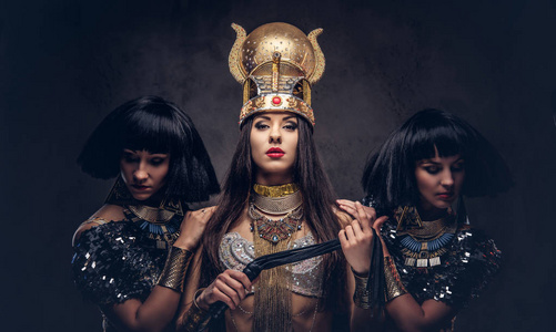 一幅傲慢的埃及王后的画像,她穿着法老的古装,有两个妃嫔.照片