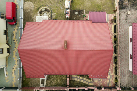 住宅金属瓦屋顶的空中俯视图,背景为围栏庭院.屋顶维修和翻新工程.