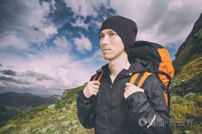 活跃的年轻人在山上徒步旅行在多云的风景背景下侧视积极的生活方式和