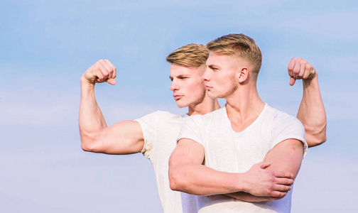 男子双胞胎肌肉兄弟天空背景.