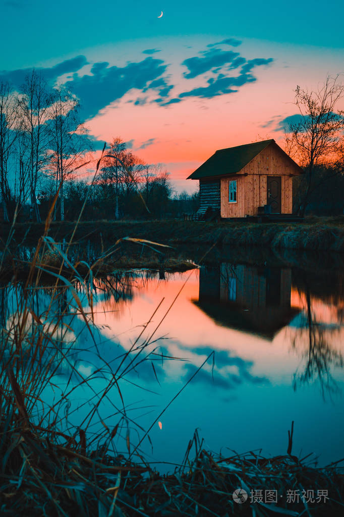 湖边的房子在暮色中倒映在水面上