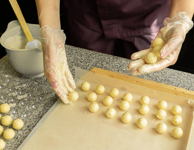 制作手工巧克力的过程.糕点师傅手中的圆形巧克力糖.选择性聚焦.照片