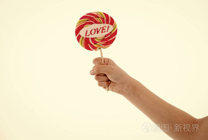 棒棒糖与爱的字母孤立在白色手里拿着糖果甜蜜的糖果漩涡情人节概念吃