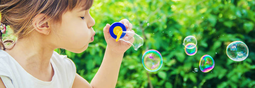 选择性聚焦.亚洲孩子吹泡泡糖儿童吹泡泡.