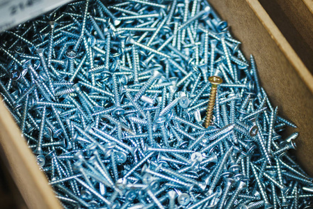 许多银色的小螺丝钉用于修理,而紧固件则在一个盒子的特写镜头里.照片
