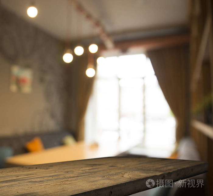 Empty wooden table in front of abstract blurred background of co