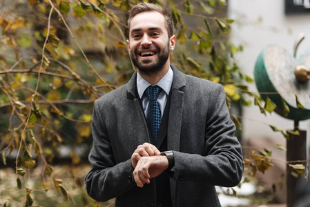 穿着西装走路的兴高采烈的年轻商人照片