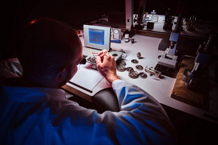 专注的钟表匠正在自己的工作室工作.照片