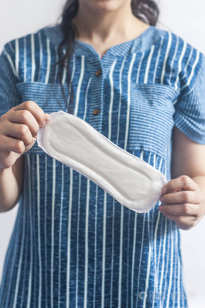 女性卫生用品.戴医用手套的妇女,白色背景下拿着卫生巾.