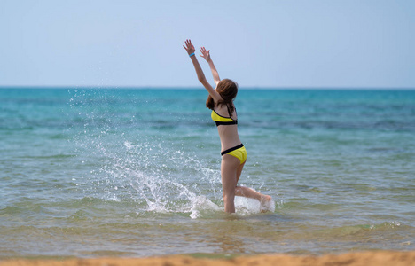 快乐的年轻女子在海上奔跑图片