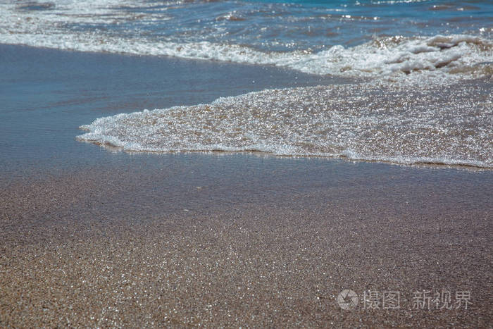 海滩和大海，海浪拍打着沙滩。