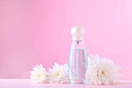 一瓶粉红色背景白花香水图片
