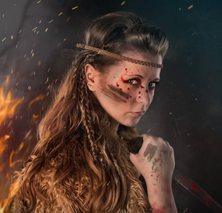 美丽的女战士年轻美丽的亚马逊女战士,手持匕首摆出战斗姿态.照片