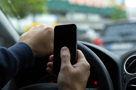 女人坐在车里用手机发信息.照片