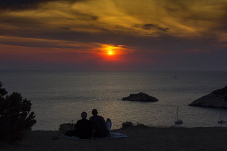 一起看海夕阳下看海的年轻夫妇照片
