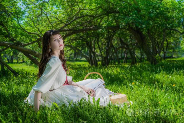 穿着白裙子的女人坐在丁香树下