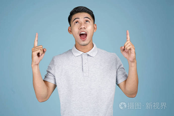 亚洲年轻帅气的男子蓝色背景面部表情和手势