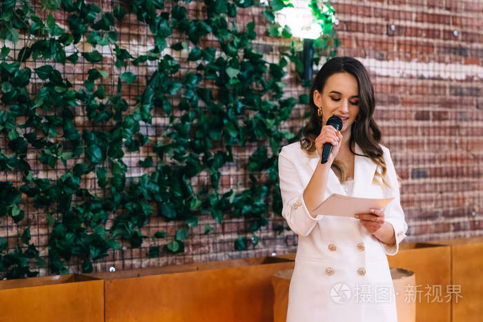 司仪拿着麦克风宣读演讲稿