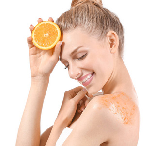 身上角质白色背景下,身上涂着橙色身体磨砂膏的年轻女子照片
