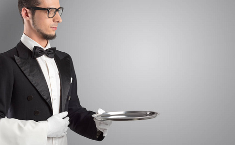 服务员端着白手套和钢托盘照片