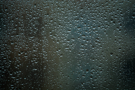 它是许多小雨滴落在窗户玻璃上.春天的雨天.照片