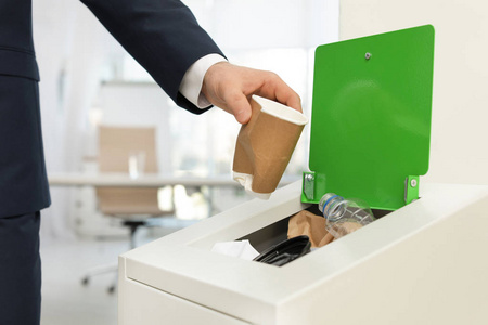 把用过的纸杯放进办公室垃圾桶的人,特写.废物回收照片