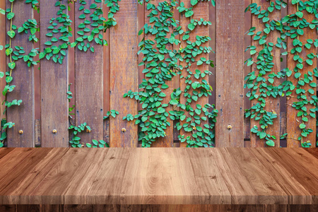 木质藤蔓墙背景的空木桌图片