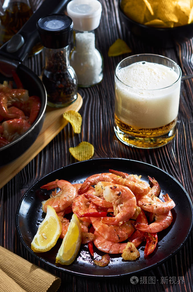 酒吧里的海鲜黑盘子配虾柠檬啤酒片