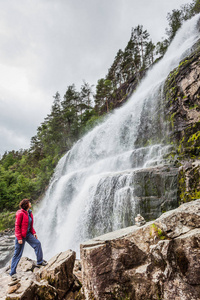 挪威斯万达尔弗森瀑布的女游客图片