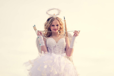 一个美丽的年轻人,金发卷发,弓和箭作为丘比特情人节.