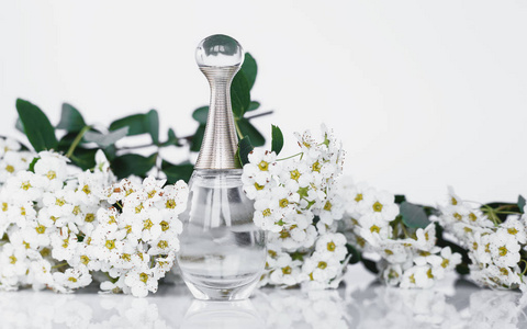 灰色背景上有香水和小白花照片