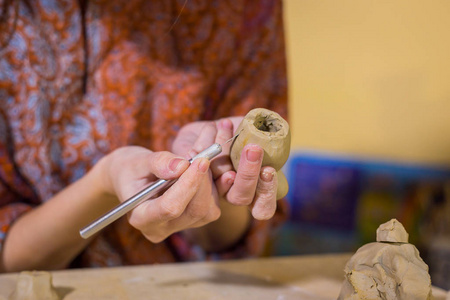 女陶工在制陶车间制作陶瓷纪念品便士哨子照片