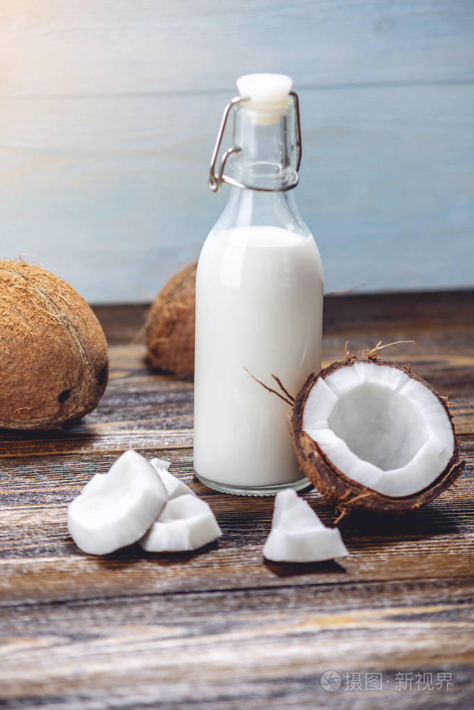 椰子奶装在一个木制背景的白色果肉瓶子里有机保健品在美容中的应用