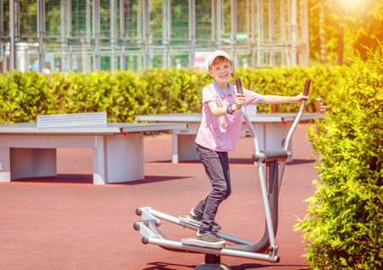 运动场上微笑的小男孩在健身房锻炼身体,快乐的孩子在公园里训练手脚