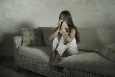 伤心沮丧,坐在家里的沙发上哭泣,沮丧和沮丧,在分手后承受着压力和
