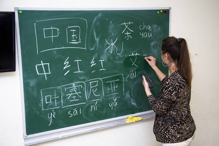 学校董事会旁边的老师写汉字图片