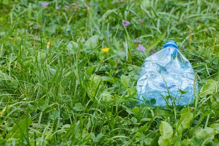 放垃圾公园草坪上放着矿泉水的塑料瓶,乱扔垃圾照片