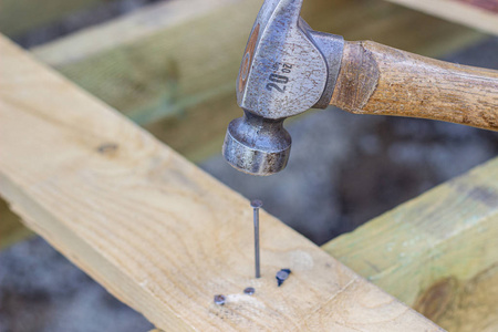 锤子在木板上刻钉子.建造房屋.照片