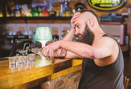 一个醉汉独自坐在酒吧里.酗酒和抑郁照片