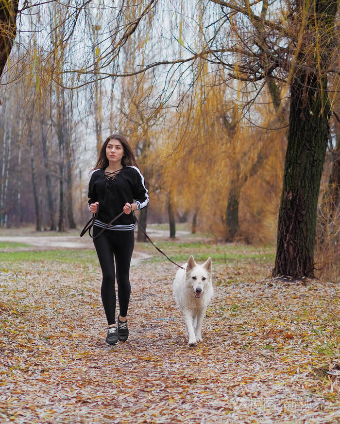 带着狗在森林里奔跑的小女孩