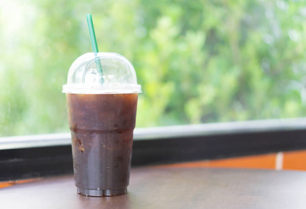 美式咖啡厅咖啡厅木桌上的特写美式冰咖啡杯,选择性聚焦照片