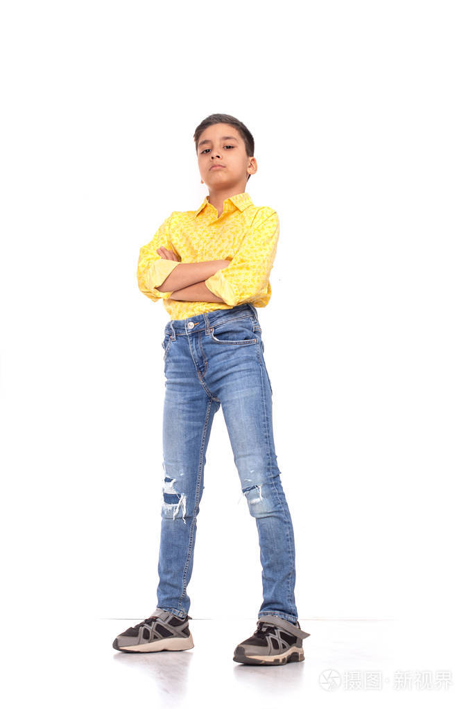 双臂交叉的严肃男孩的全身肖像