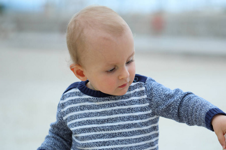 沙滩上穿着毛衣的漂亮男婴图片