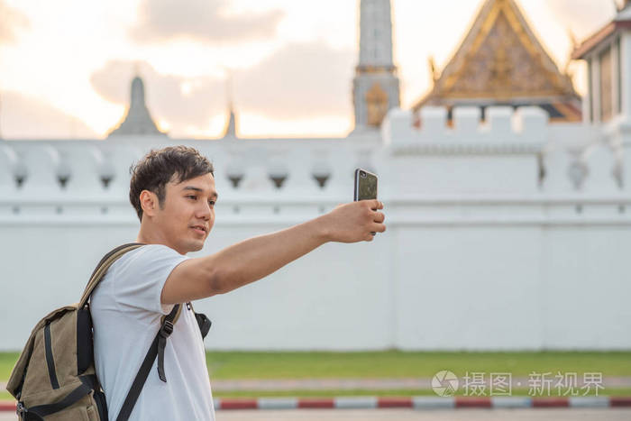 泰国曼谷，亚洲博客男子旅游，背包男用手机制作视频日志，并在社交媒体上生活，同时在度假旅行中度过甜蜜时光。男人的生活方式在城市概念