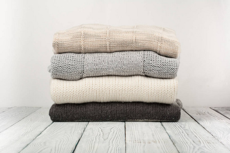 木制背景上的一堆针织冬装,毛衣,针织品,文本空间.照片