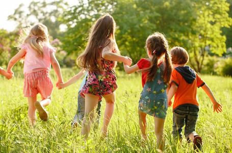 一群孩子在公园里的草地上玩耍和奔跑照片